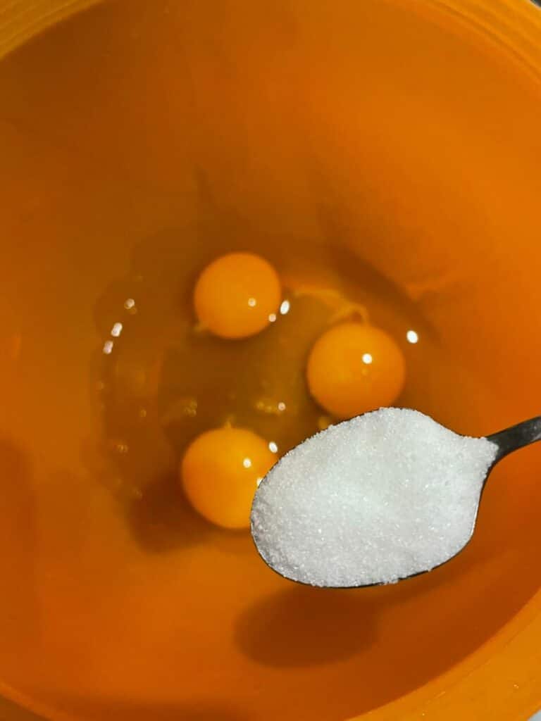 Разбиване на яйцата със солта и захарта